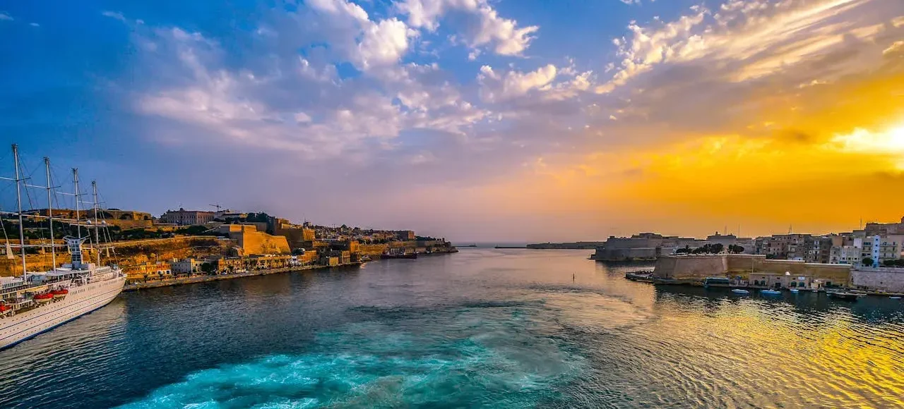 Landscape photography of a serene body of water under a bright blue sky in Malta, showcasing the island’s natural beauty and coastal charm.